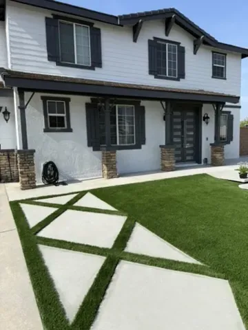 Exposed aggregate concrete driveway leading to a modern home, emphasizing durability and curb appeal